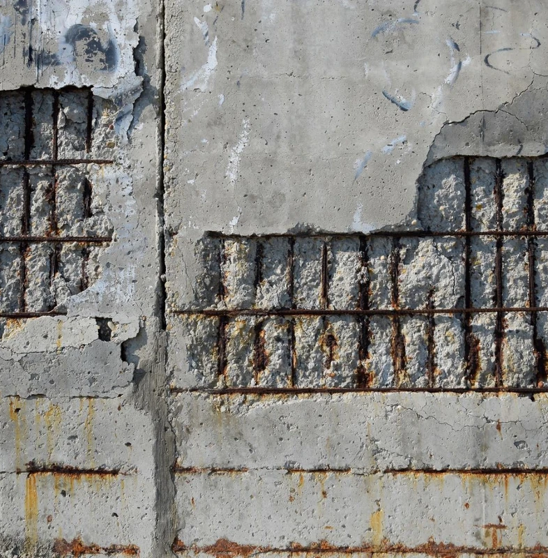 damaged concrete wall with exposed rebar